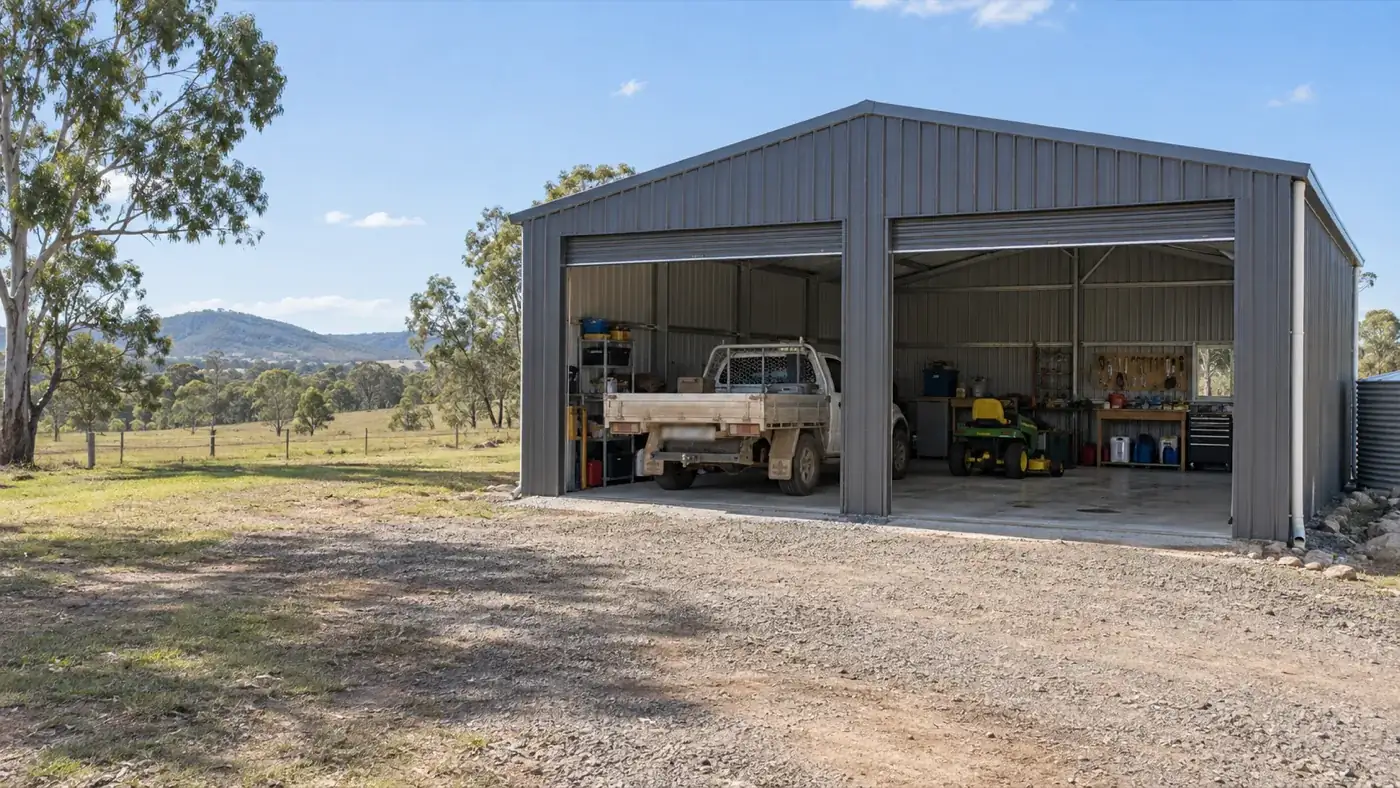 A grey shed with a ute and workbenches inside